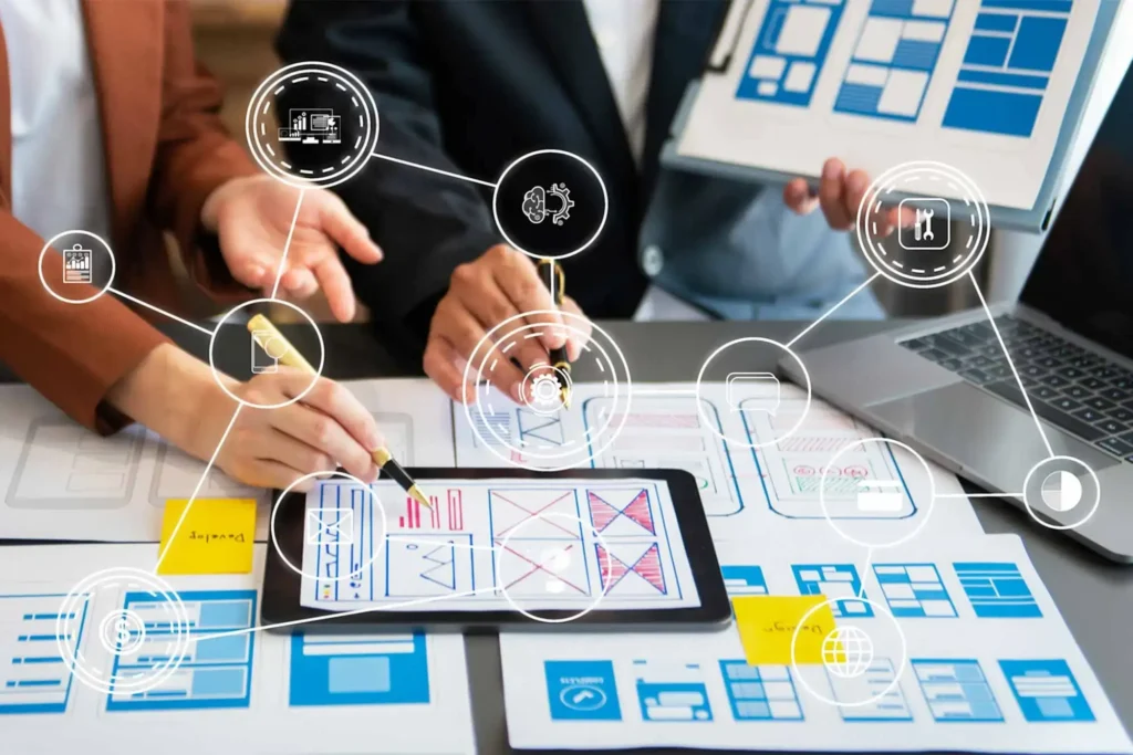 Team of professionals collaborating over tablets and printed layouts with futuristic data icons and charts overlaying the workspace.