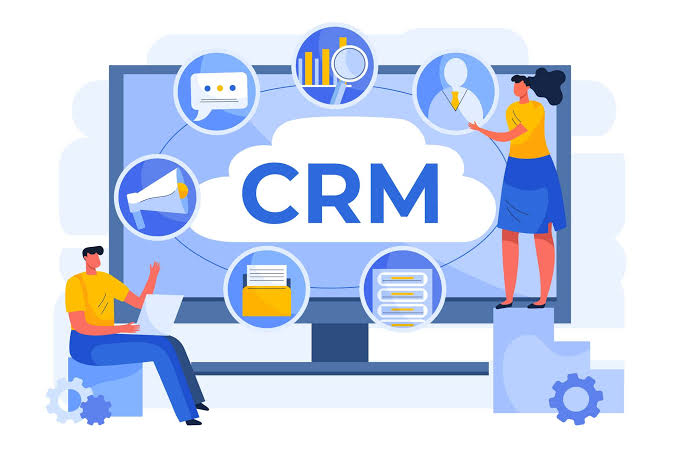 Two people collaborate around a monitor showing a cloud-labeled CRM with connected circular icons for chat, reports, files, and data servers on a blue background.